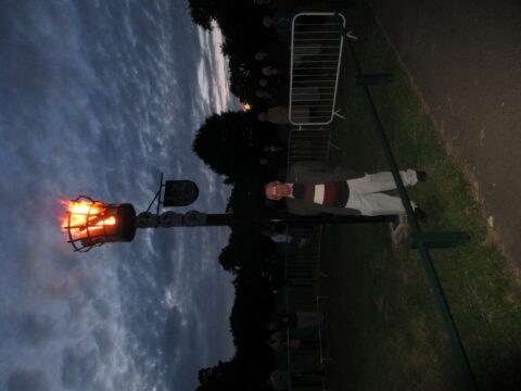 Cllr Porter standing underneath the lit beacon.